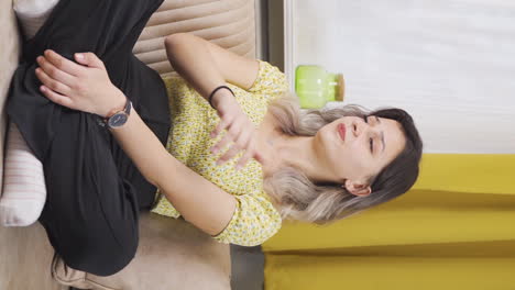 Vertical-video-of-Unwell-young-woman-watches-out-the-window-to-relax.